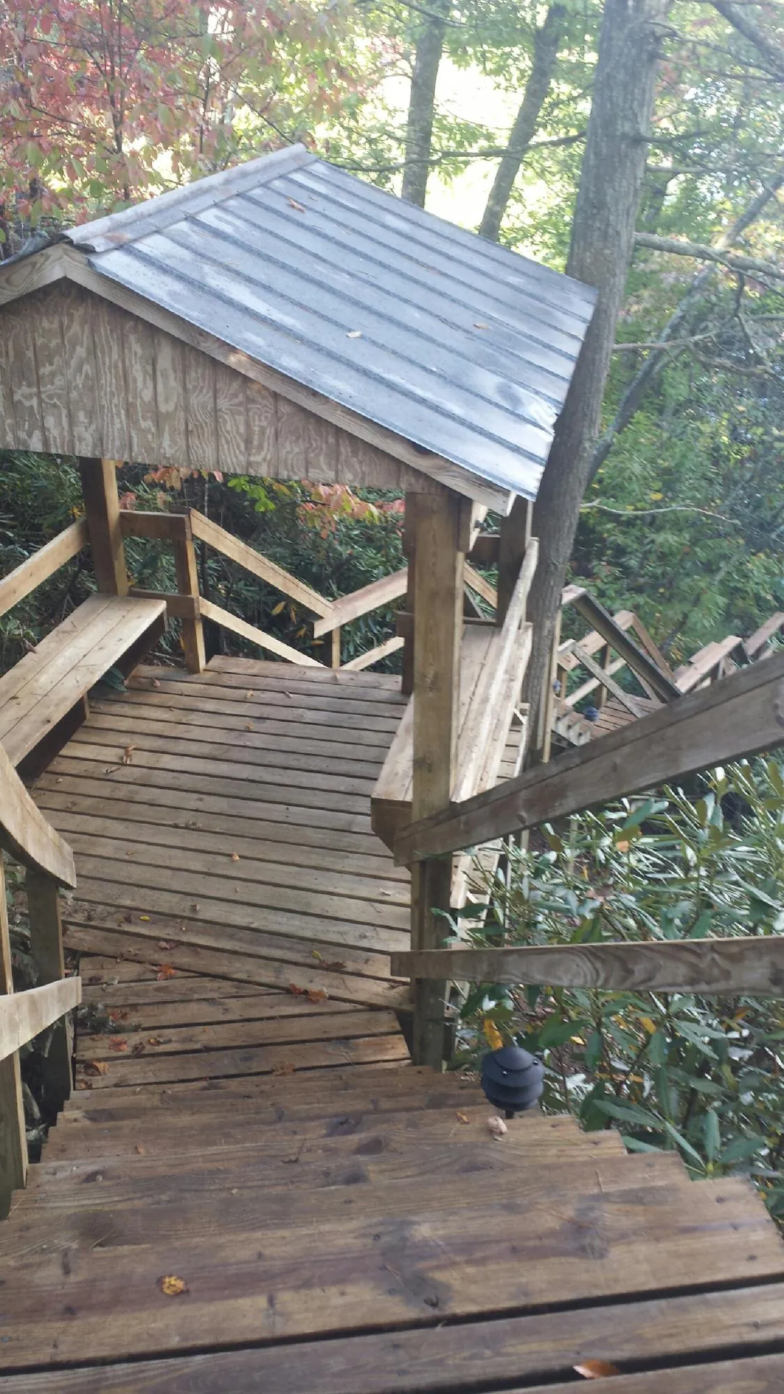 Metal roofed shelter over wooden steps on a wooded walkway — Skylight Repair & Installation work by our crew in Brooklyn