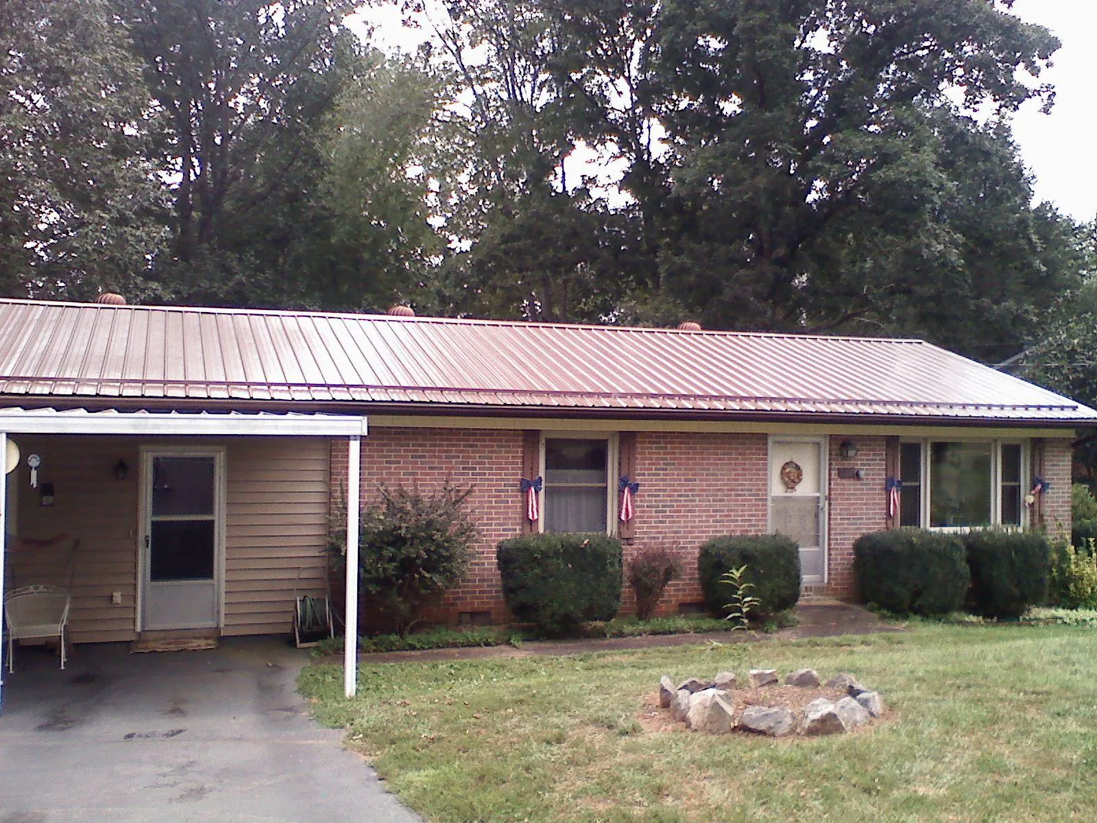 Bronze metal roof and carport on a brick ranch home — Roof Repair work by our crew in Brooklyn